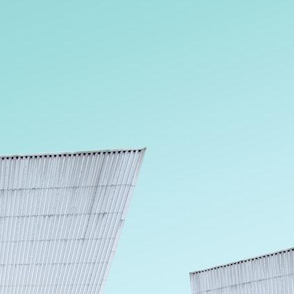 A sleek steel cabin structure under construction against a clear sky.