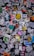 A chaotic collage of various stickers and posters overlapping each other on a dark surface. The stickers feature different designs, logos, and text, with a mixture of colors and styles. Some are partially torn or obscured, creating a layered appearance.