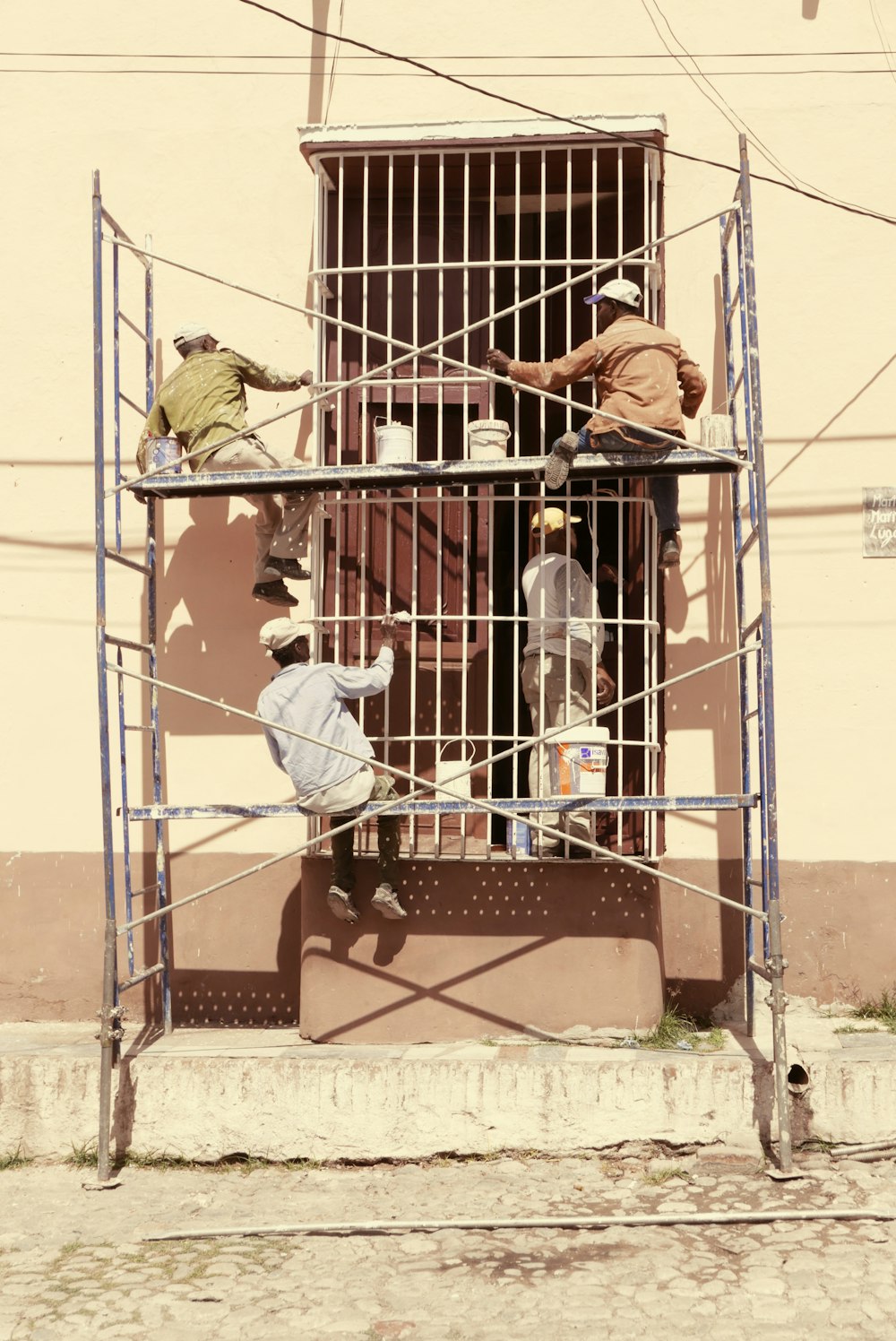 men painting gate