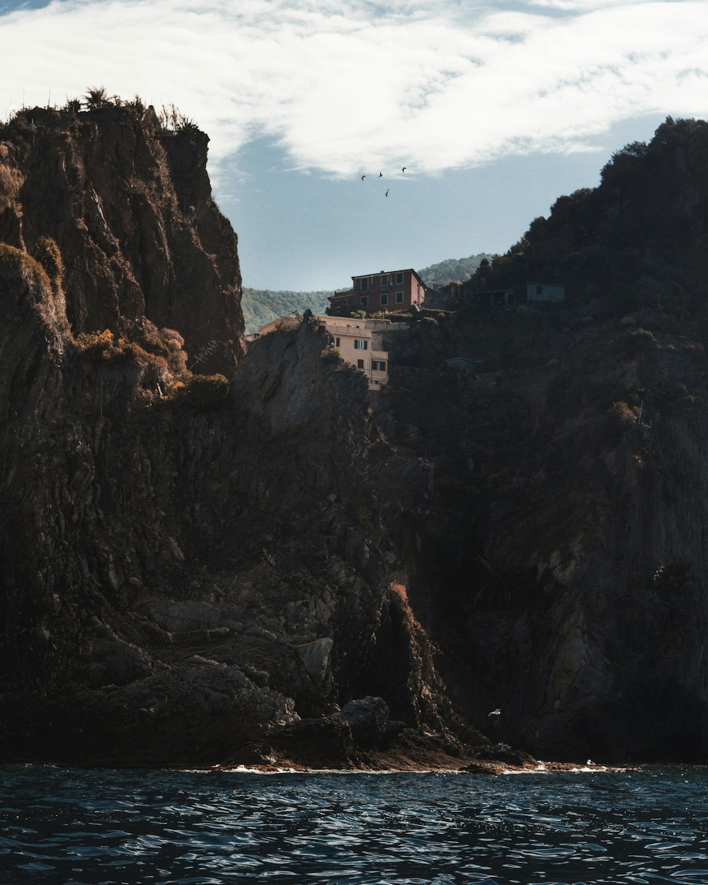 brown concrete building near the cliff during daytime