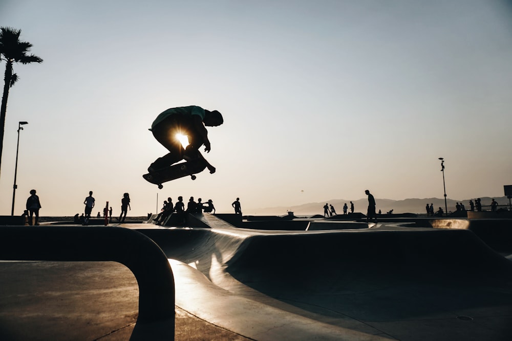 silhouette of man riding skateboard taken at daytime