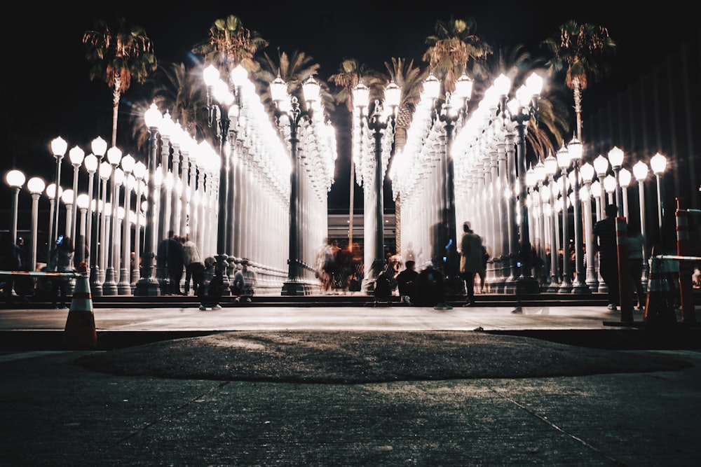 time lapse photography of people walking near lampposts