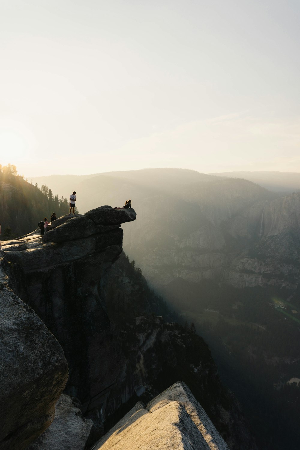 Menschen, die tagsüber auf einer Klippe mit klarem blauem Himmel stehen