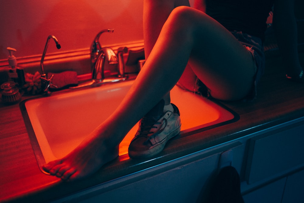 woman sitting on sink top inside room