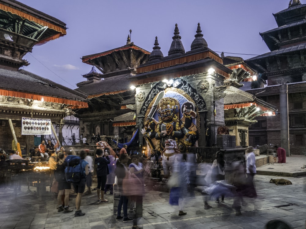 people standing in front of religious statue under blue sky