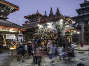 people standing in front of religious statue under blue sky