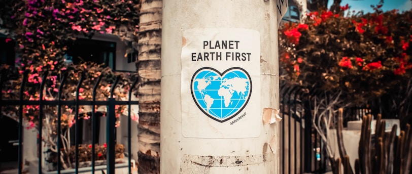 Planet Earth First signage sticked in gray post outdoors