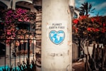 Planet Earth First signage sticked in gray post outdoors