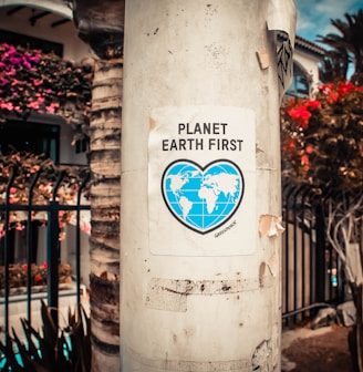 Planet Earth First signage sticked in gray post outdoors