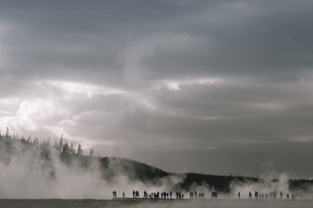 Gente cerca de la montaña con niebla