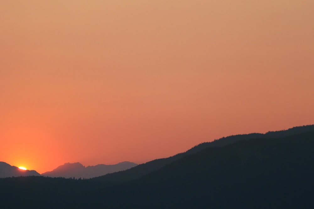 silhouette photo of mountain at sunset