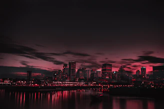 A cinematic shot of a cityscape at dusk with red and black tones.