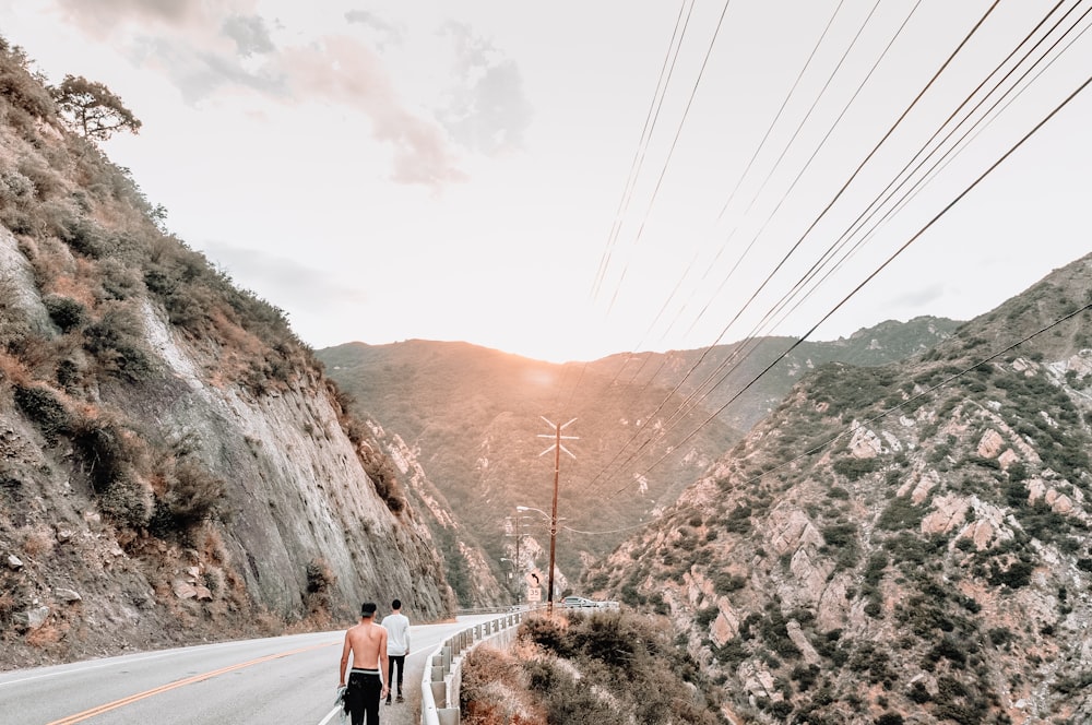 man in black shorts walking on gray road