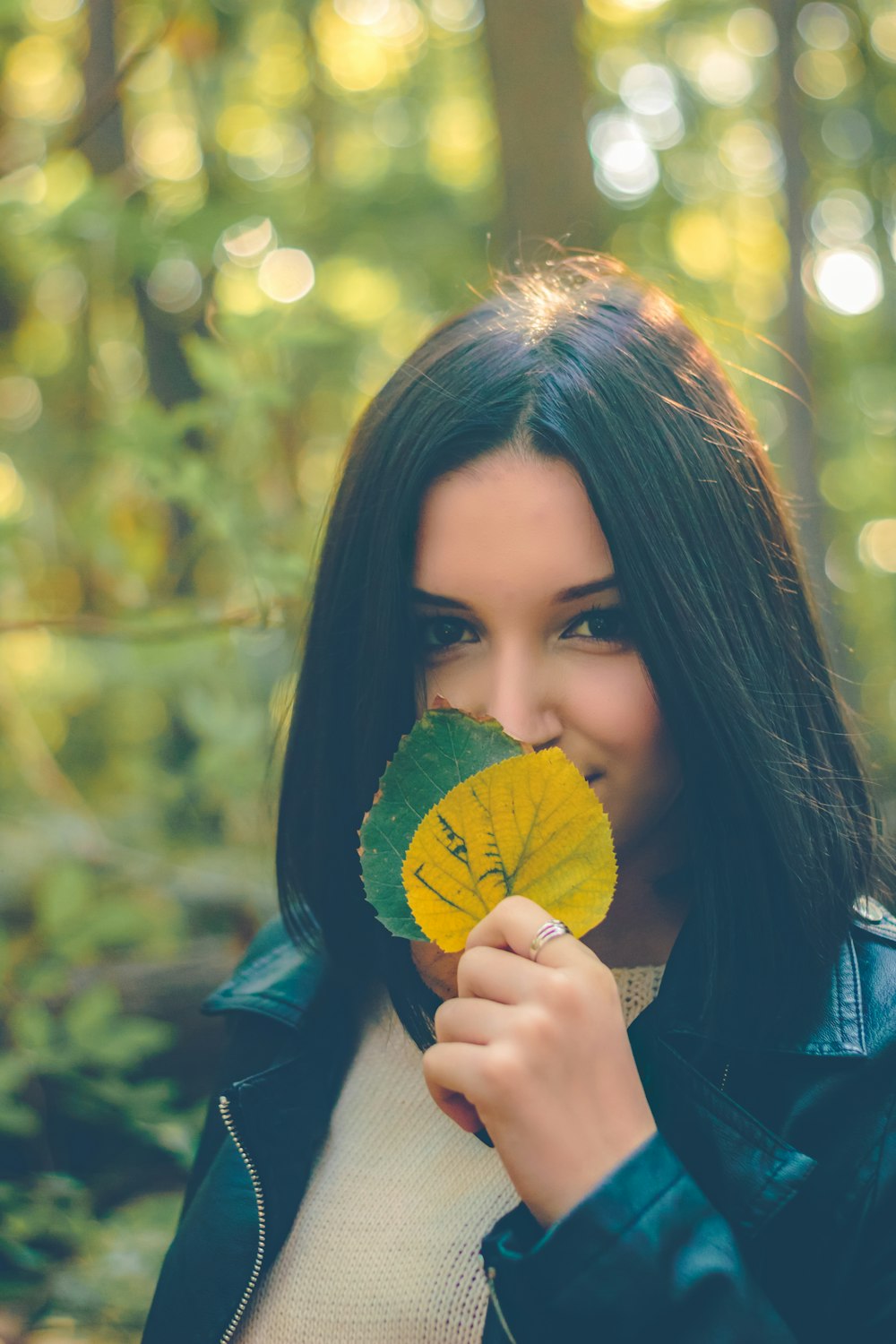 woman holding yellow and green leaves