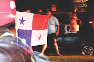 A group of truckers wearing Libertad Ruda hoodies gathered around a campfire at dusk.