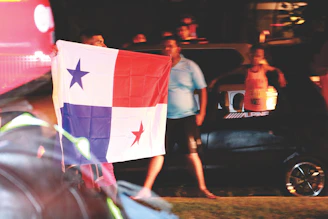 A group of truckers wearing Libertad Ruda hoodies gathered around a campfire at dusk.