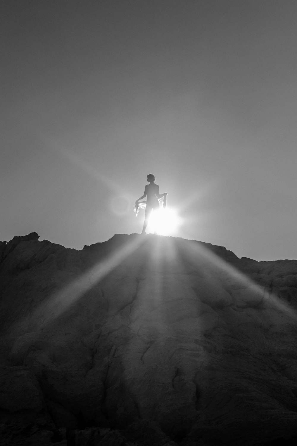 山の崖の上に立つ女性のシルエット