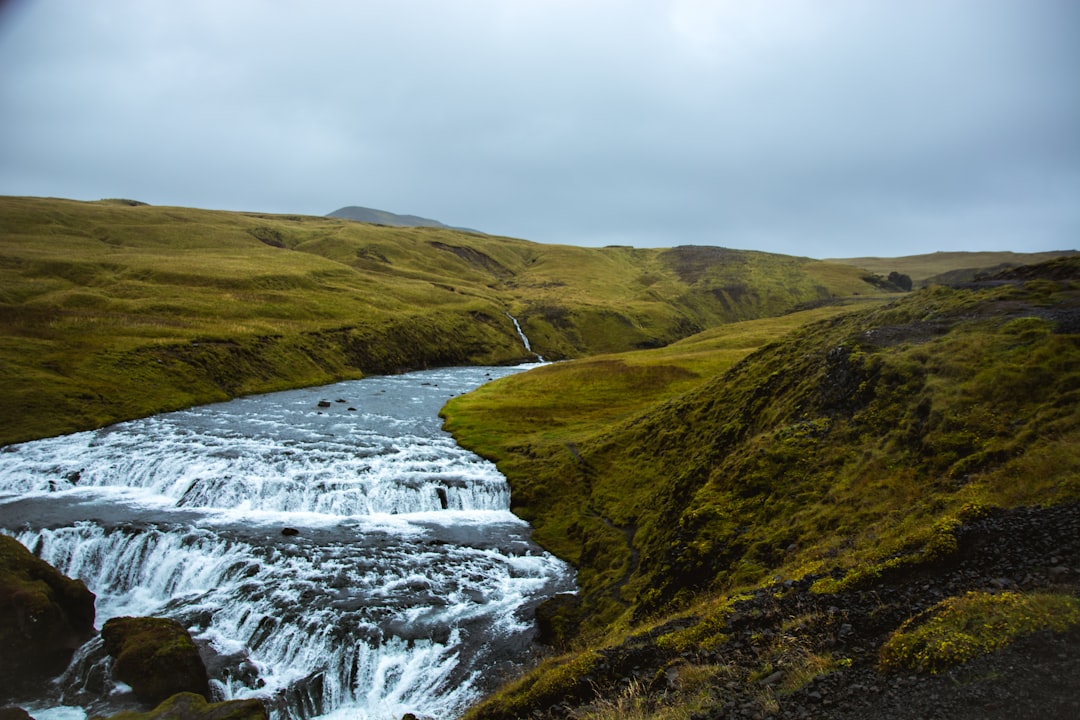 flowing body of water under white sky