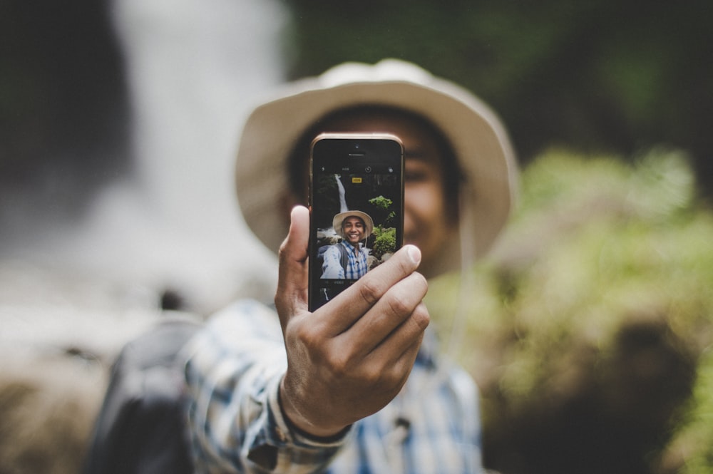 man wearing brown hat taking selfie