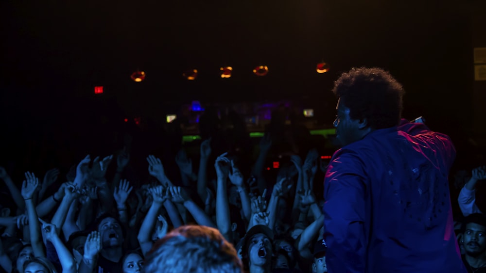 back view of man dancing in front of many people inside bar