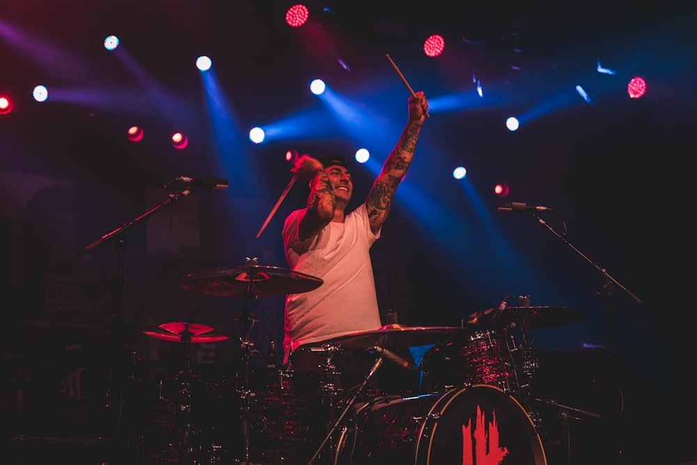 man playing drums with spotlights