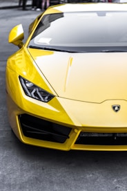 yellow sports car on top gray road