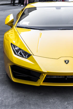 yellow sports car on top gray road