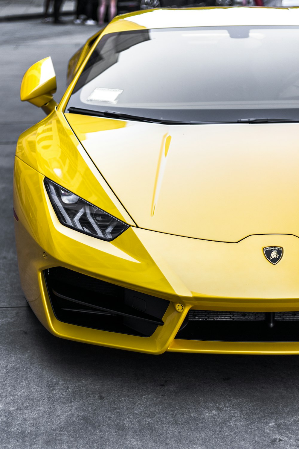 yellow sports car on top gray road