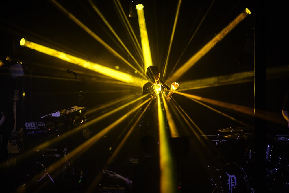 person singing on stage with spot lights