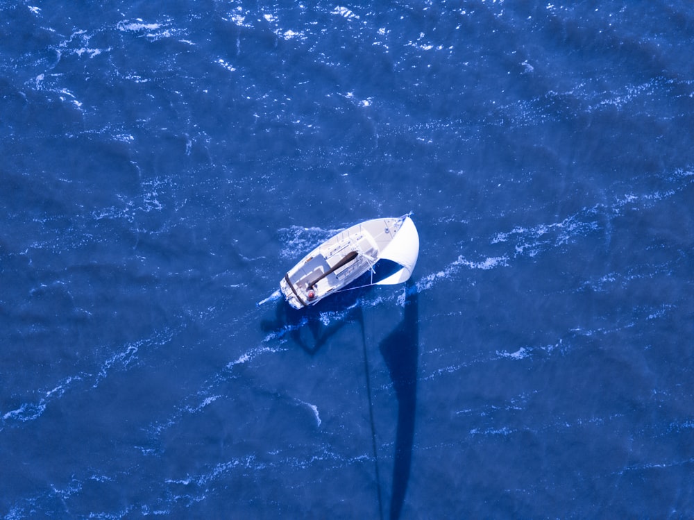 Luftaufnahme eines Bootes, das auf dem blauen Ozean segelt