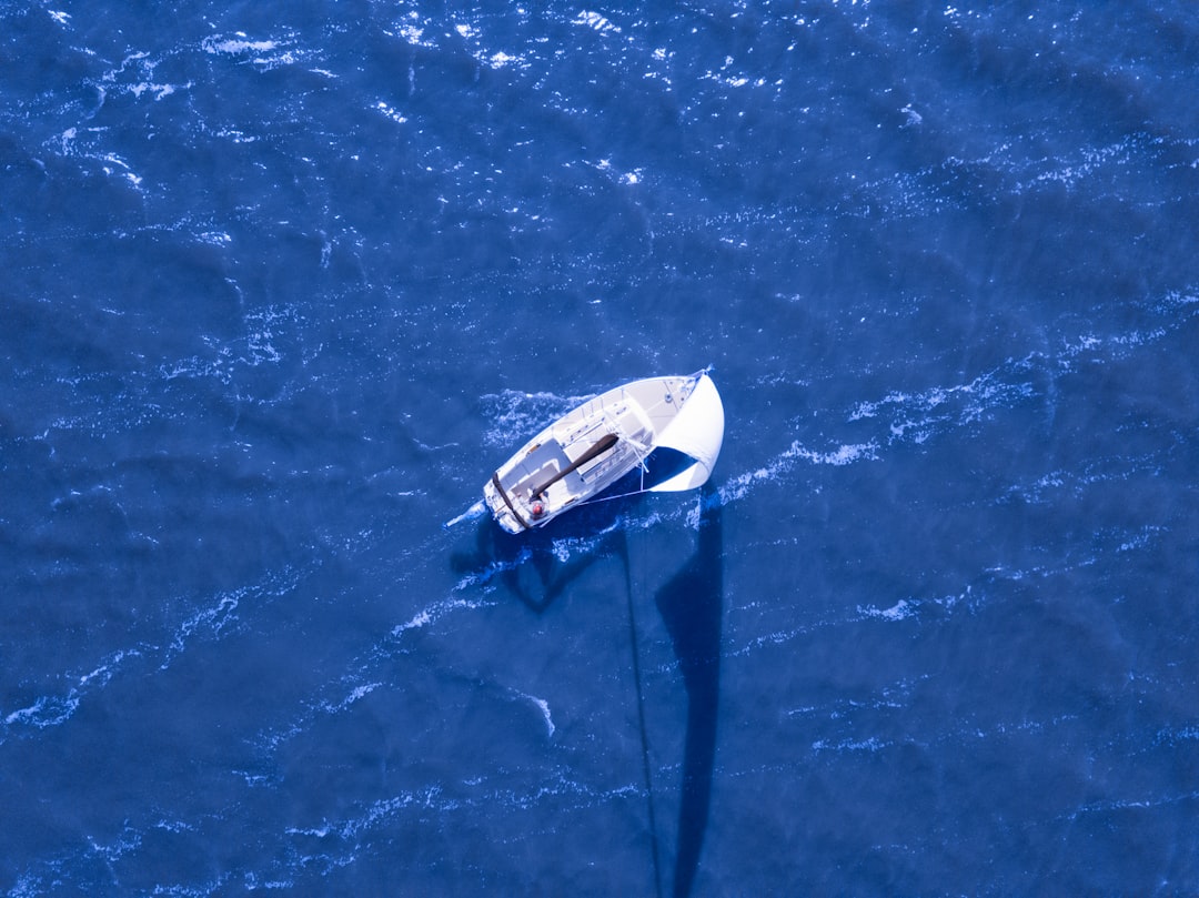 aerial view of boat sailing on blue ocean, Sailing Away