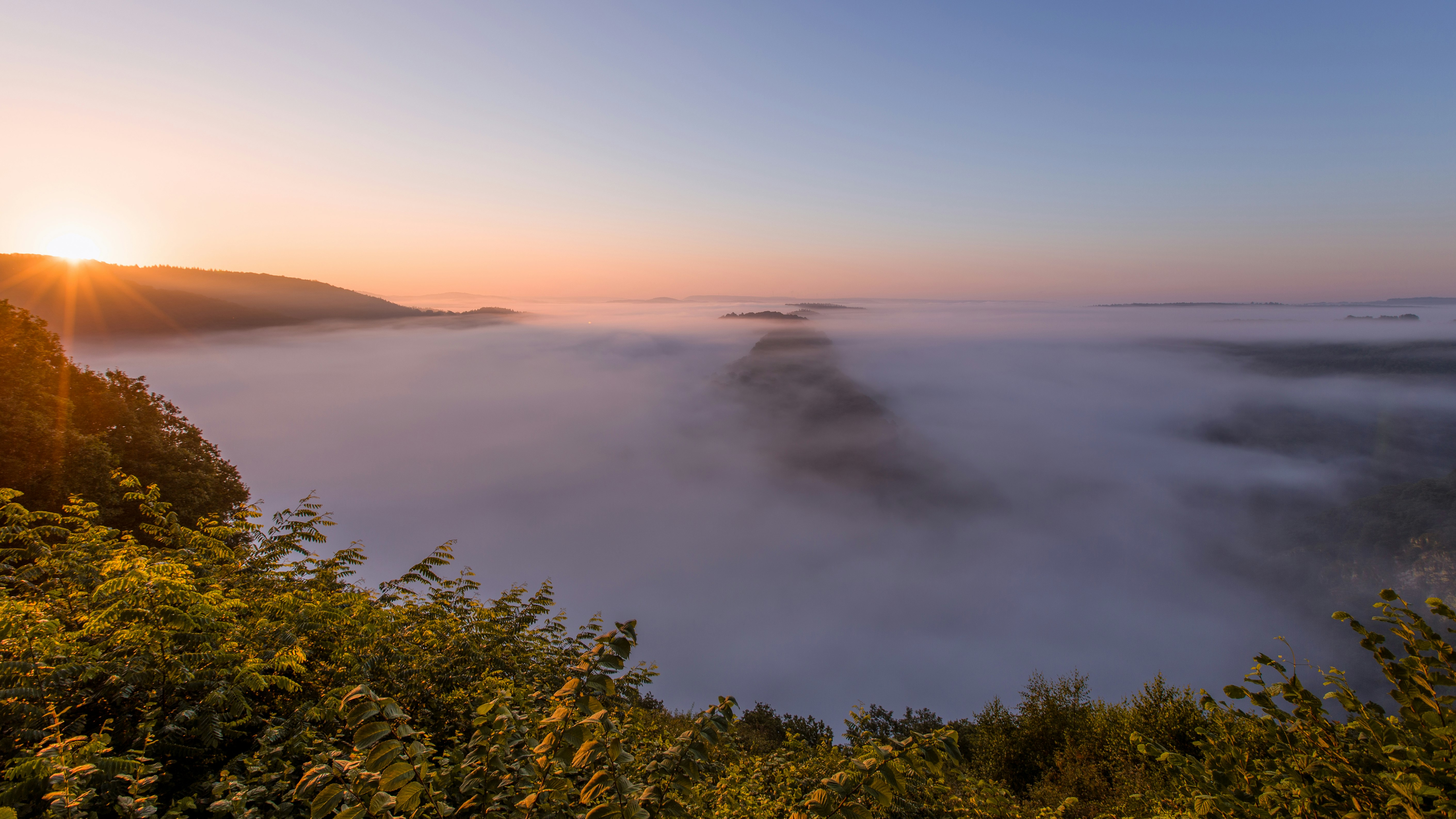 misty body of water during golden hour