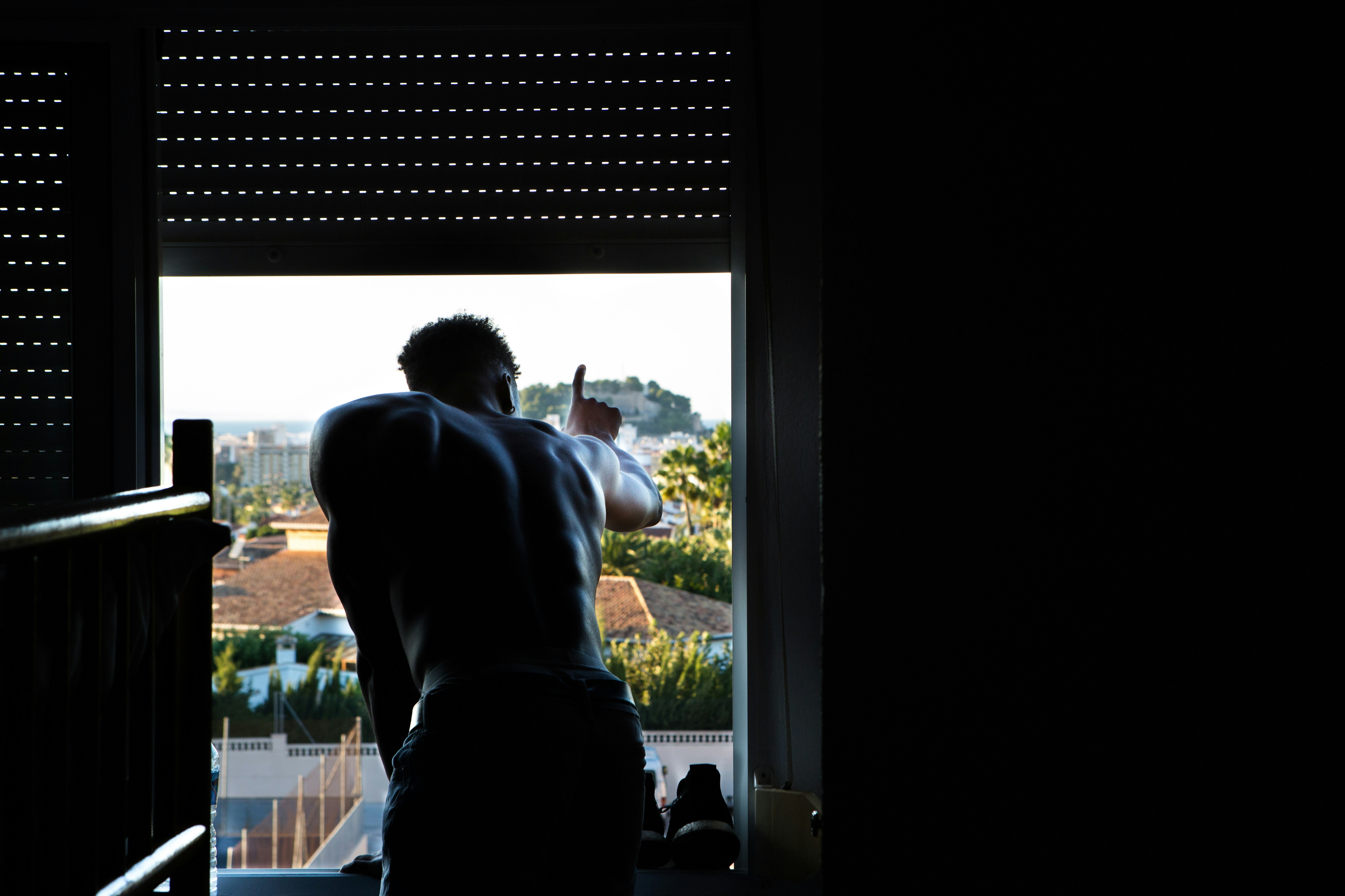 man leaning to window during daytime
