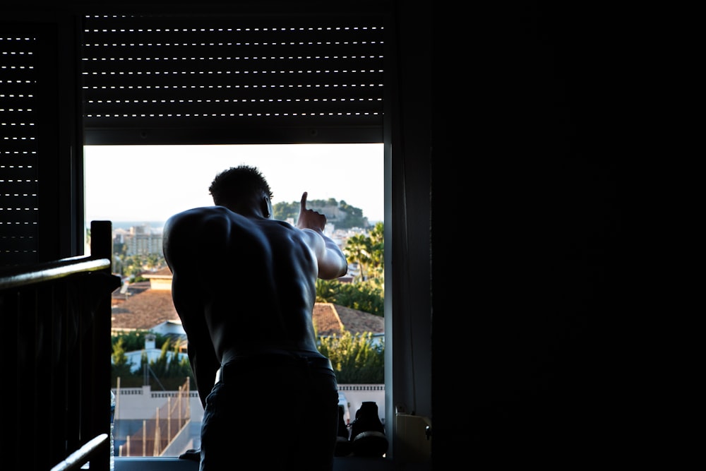 man leaning to window during daytime