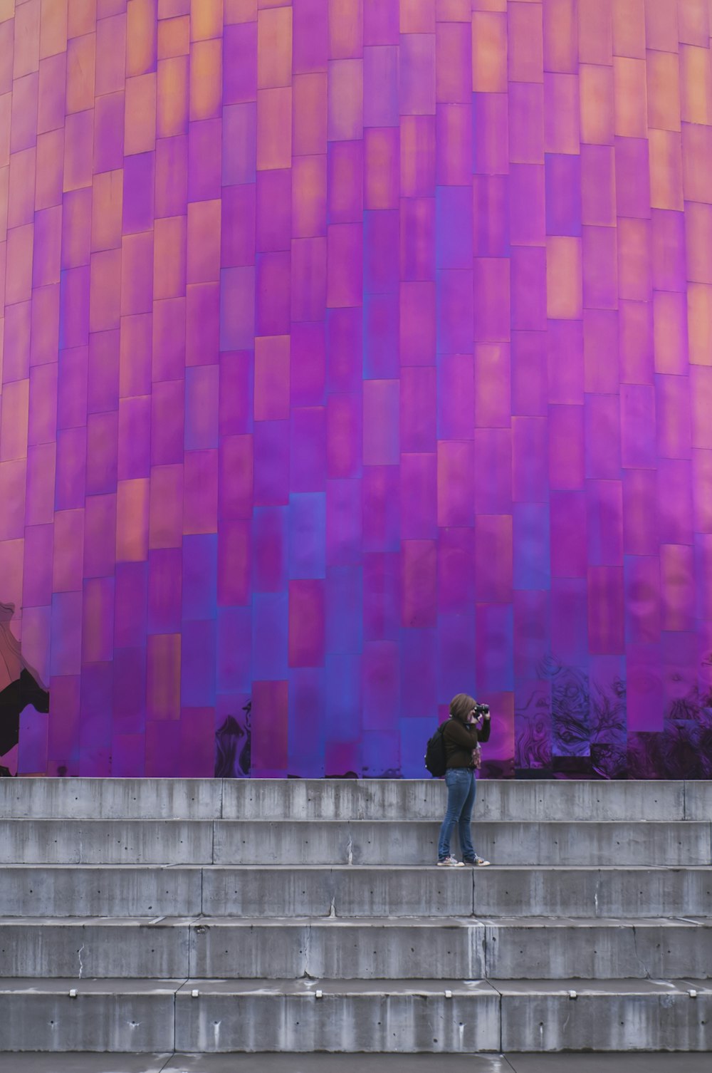 woman standing near the wall taking a picture