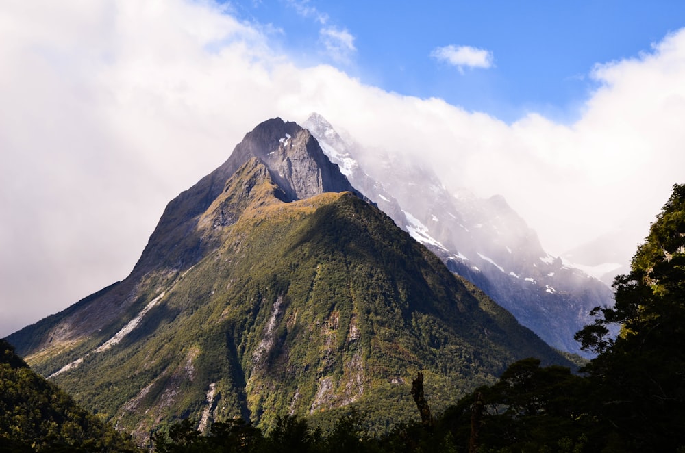 green mountain under white clouds and blue sky