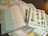 An open book with text in two columns lies on a cloth with a decorative leaf pattern. A notebook with colorful geometric letters spelling 'YOU ARE ENOUGH' and '1 PETER 2:9' is placed on top of the book, and a pen rests between the pages.