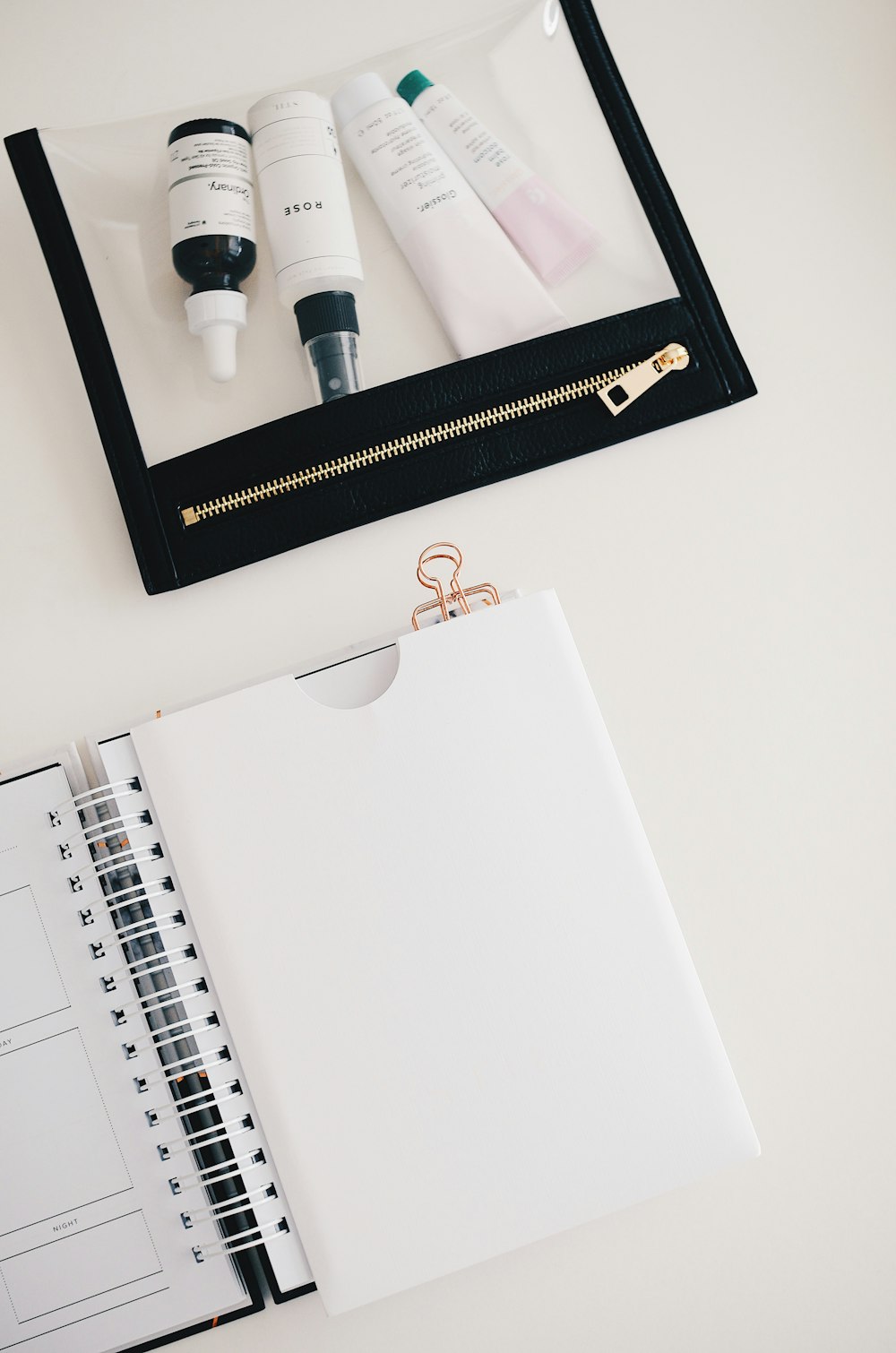 Cuatro productos de belleza en el paquete cerca del cuaderno