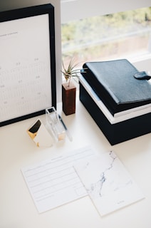 A neatly organized desk with natural fiber baskets, a woven planner, and a small potted plant.
