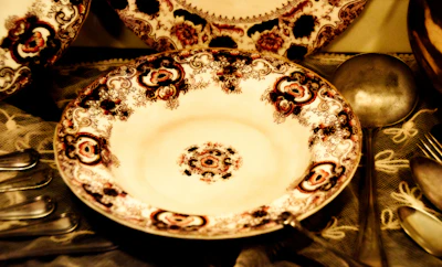 Close-up of a custom dinner plate featuring a delicate floral pattern and matching spoon.