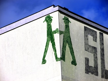 Two professionals shaking hands in front of a colorful mural symbolizing partnership.
