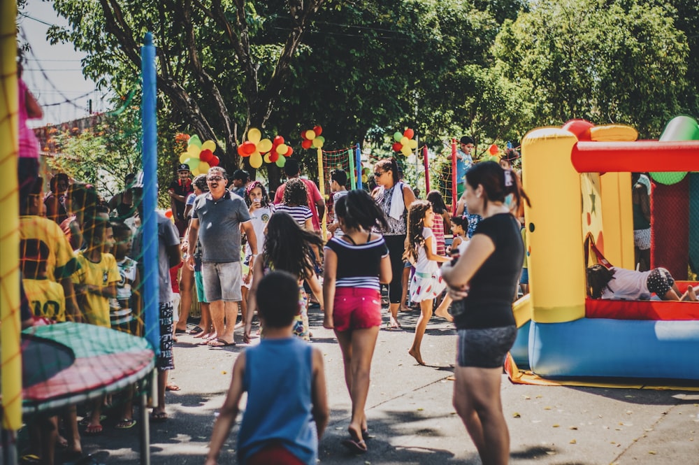 Personas al aire libre con casa inflable y trampolín durante el día