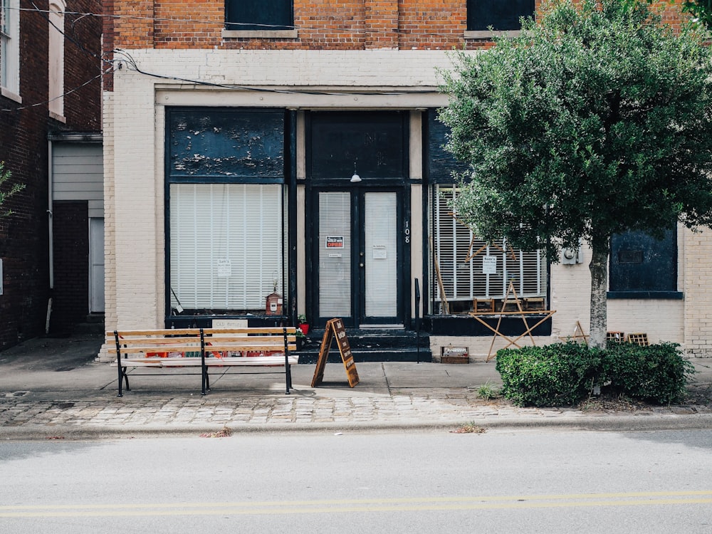 brown wooden bench in front of black store