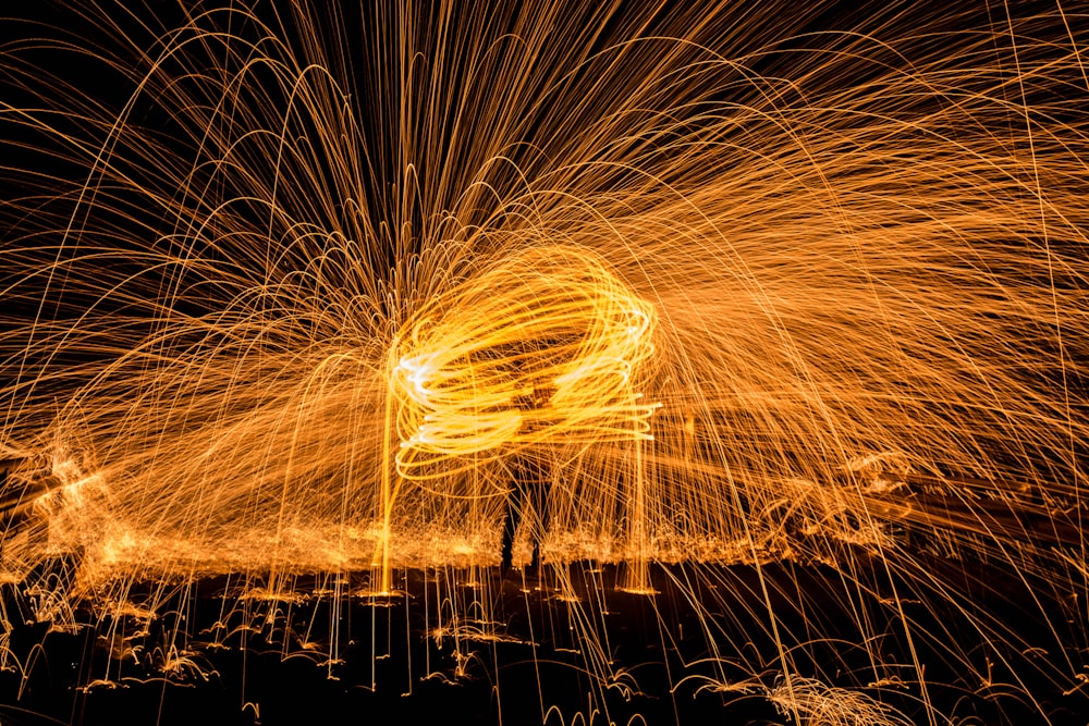 steel wool photography on man standing on black surface
