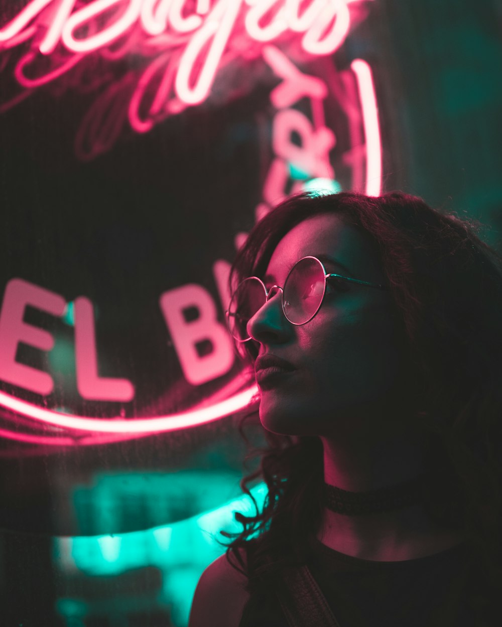 Foto de foco seletivo da mulher com fundo de sinalização de luz neon