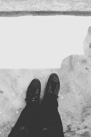 Monochrome shot of a pair of high-top shoes against a minimalist city backdrop.