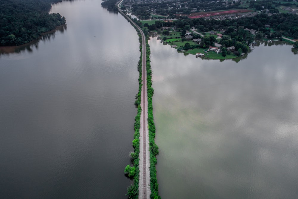 road between body of water during day