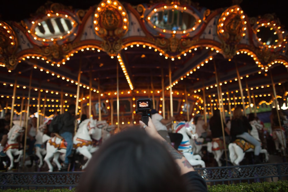 people riding merry go around at the carnival during night