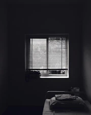 A bright, tidy bedroom with a single bed and soft natural light.