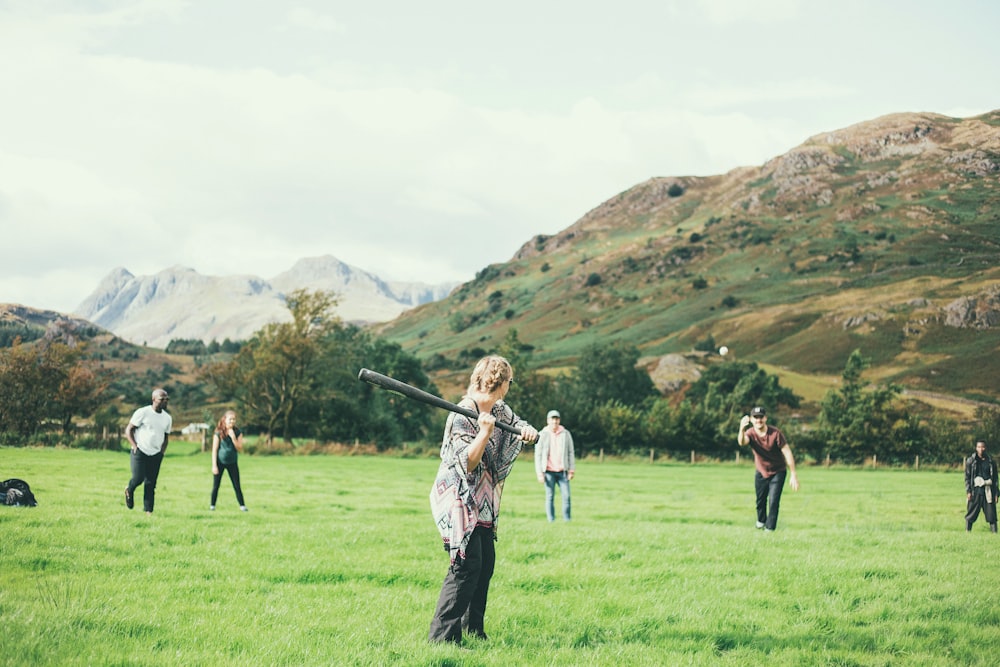 people playing baseball game on green grass field during daytime